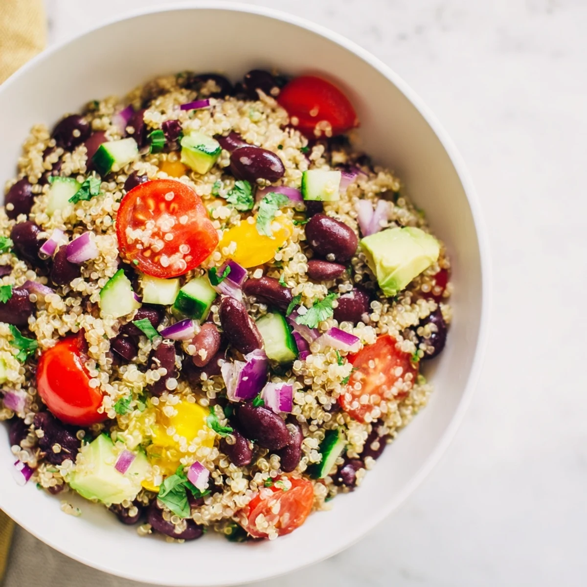 This vibrant quinoa and black bean salad is ready to eat, full of fresh vegetables.