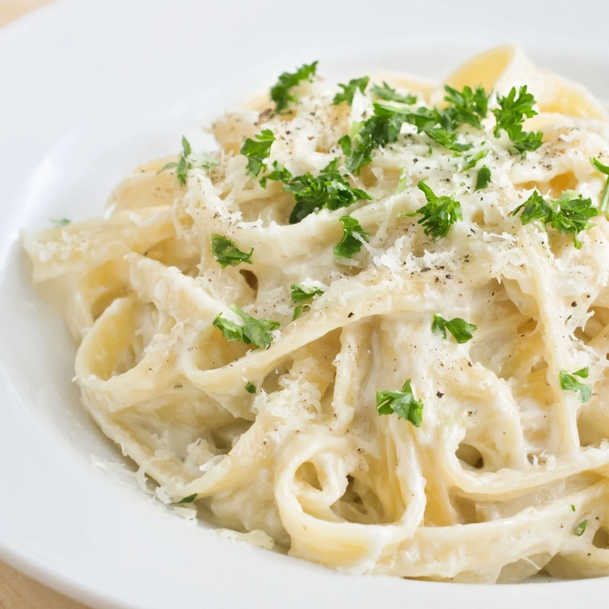 Creamy Cottage Cheese Alfredo Sauce, ready to coat pasta, with fresh parsley garnish sprinkled on top.