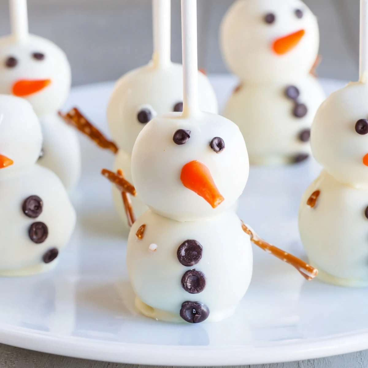 Oreo Snowman Cake Pops, dipped in white chocolate, are perfect winter dessert party treats.