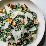 Close-up photo of a delicious Kale Caesar Salad with perfectly toasted homemade croutons and shaved cheese.