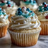 Close-up of Cancer birthday cupcakes, adorned with glistening pearl fondant and fluffy buttercream frosting.