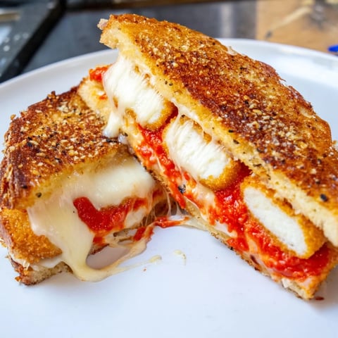 Golden-brown Mozzarella Stick Grilled Cheese, with melted cheese and ready to dip in marinara.