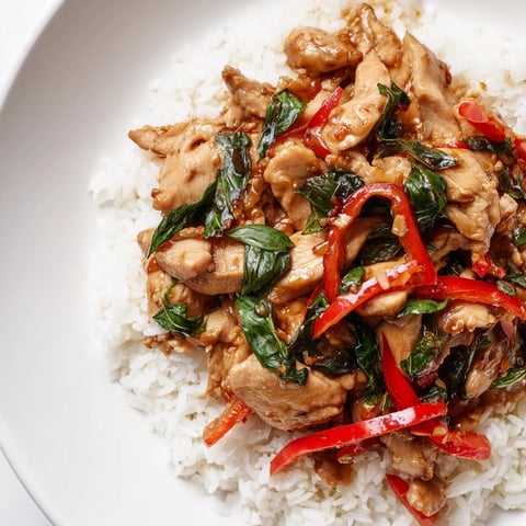 Steaming Thai Basil Chicken Bowls, ready to eat, with vibrant basil and fluffy rice presented.