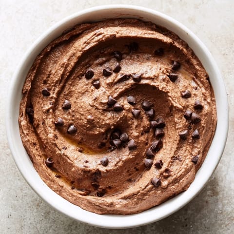 Silky smooth chocolate hummus, swirled and topped with chocolate chips, ready for serving.