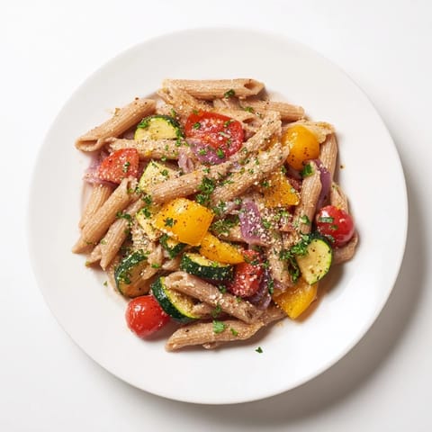 Mediterranean lentil pasta showcases wholesome whole wheat pasta mixed with colorful roasted vegetables and lentils.