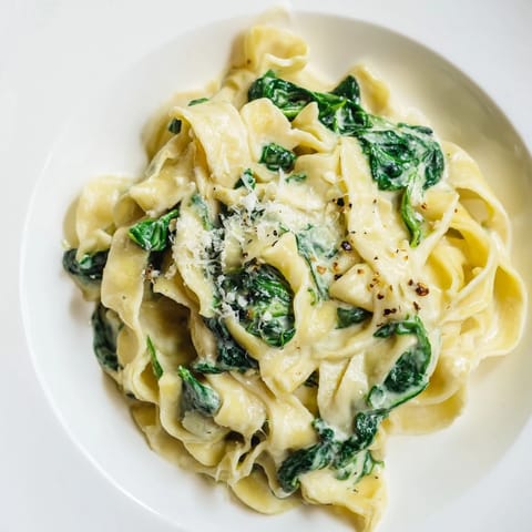 Fresh spinach and minced garlic simmer in a rich cream sauce over tender egg noodles.