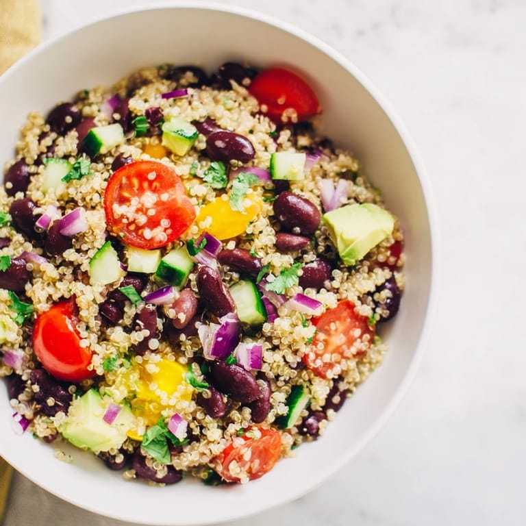 This vibrant quinoa and black bean salad is ready to eat, full of fresh vegetables.