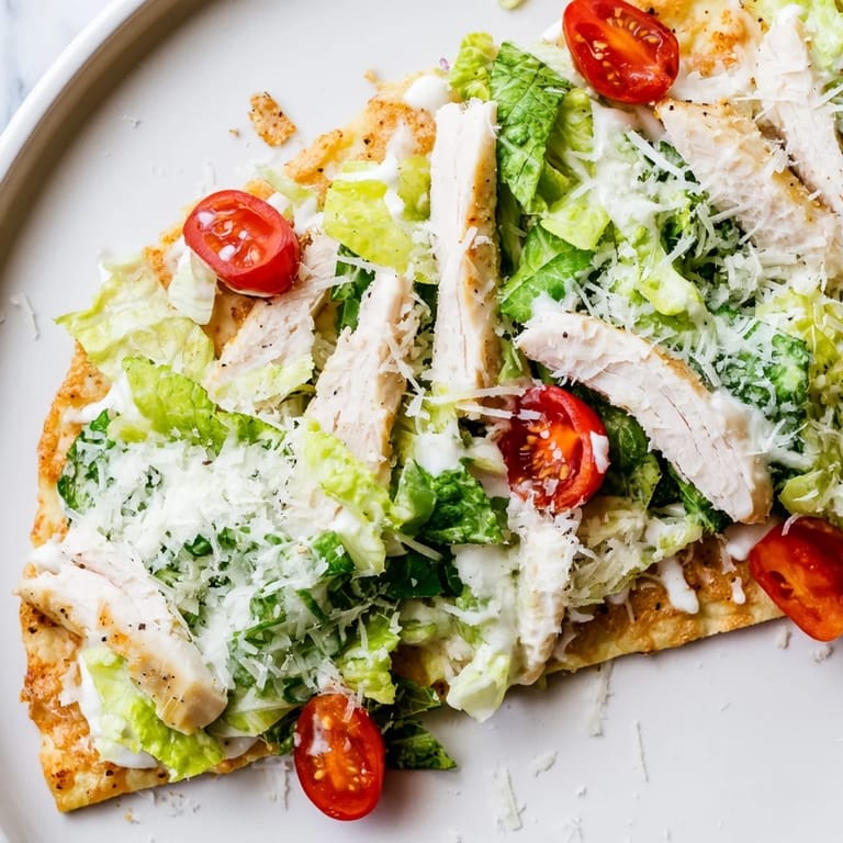 Golden-baked flatbread layered with Caesar salad, grilled chicken, and Parmesan, perfect for a quick weeknight dinner.