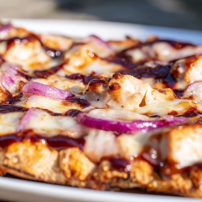 Slice of savory BBQ Chicken Flatbread with sweet onions and fresh cilantro, served for dinner.