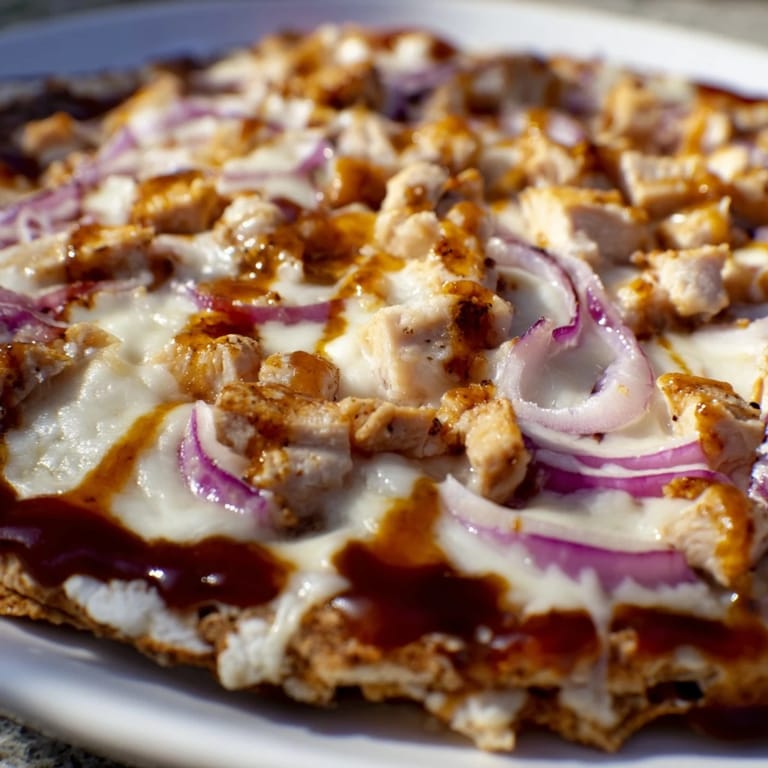 Golden crispy BBQ Chicken Flatbread topped with tender grilled chicken and a drizzle of tangy sauce.  