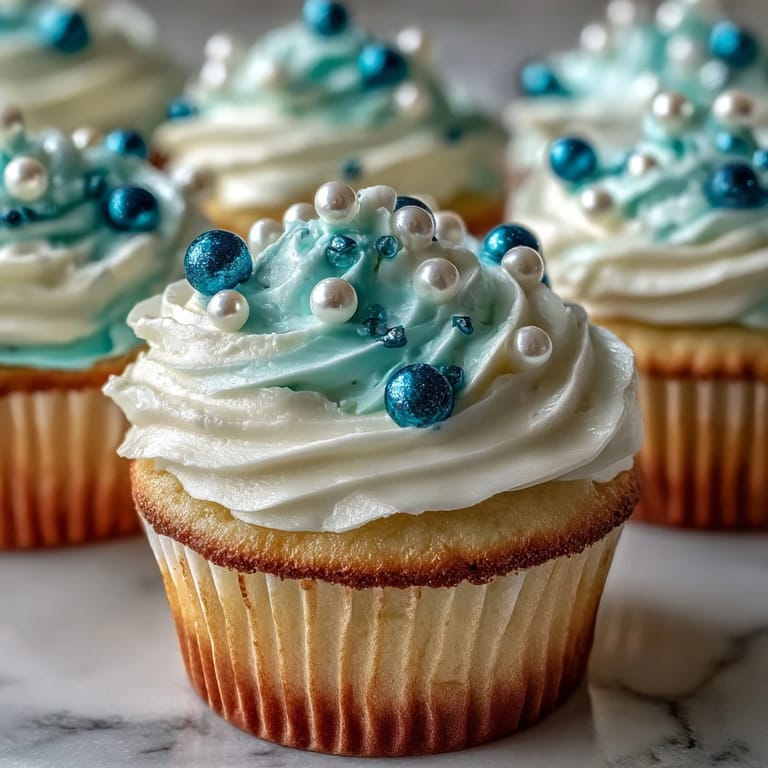 Delightful Cancer birthday cupcakes iced with creamy swirls and topped with shimmering, zodiac-inspired fondant.