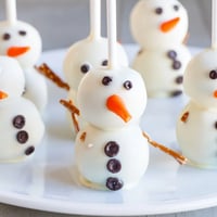 Oreo Snowman Cake Pops, dipped in white chocolate, are perfect winter dessert party treats.